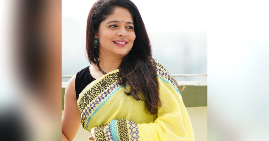 Woman wearing a lemon yellow soft cotton handloom saree with a woven border, draped for everyday wear